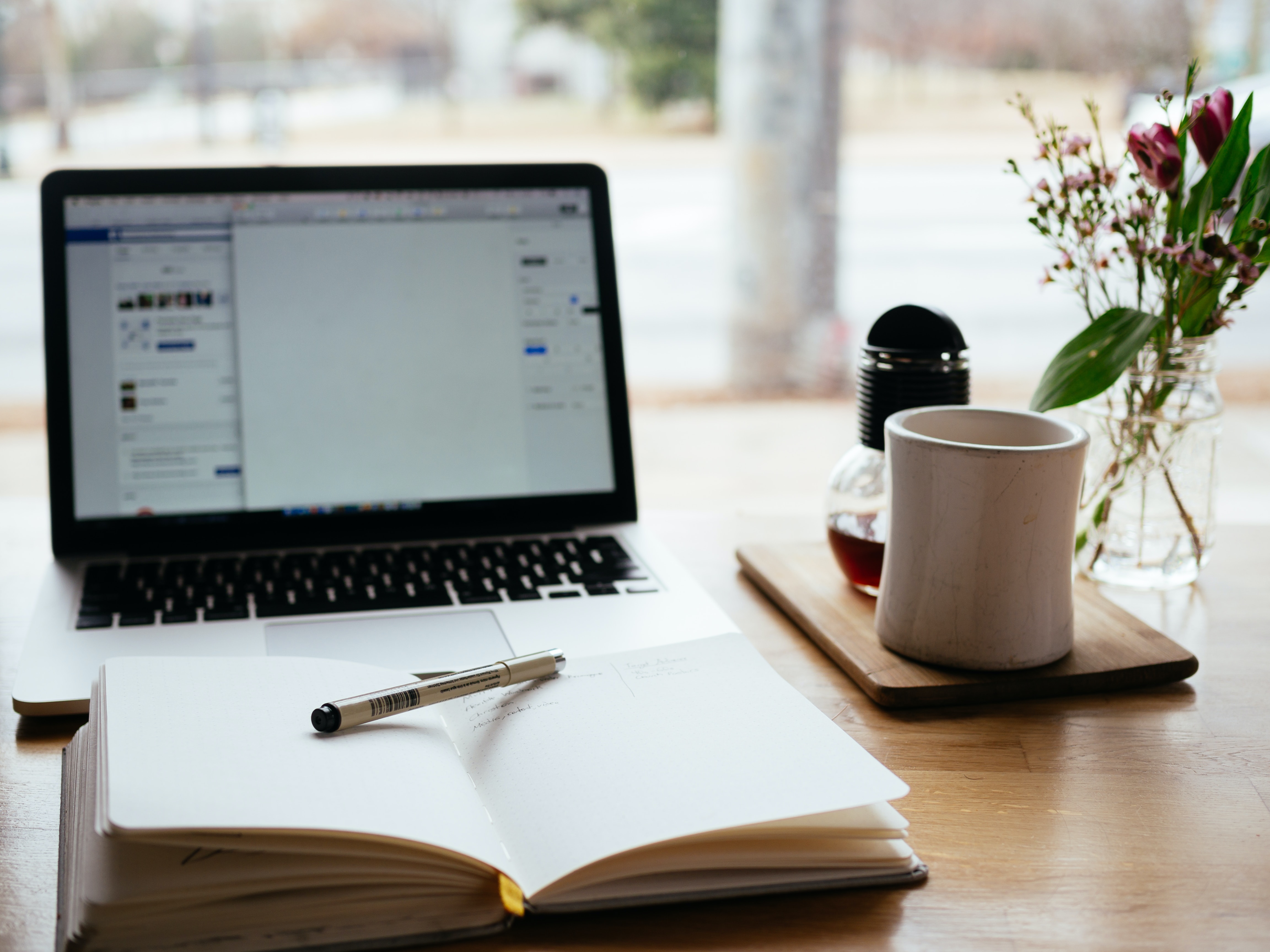 Un PC portable et un bloc-notes sur un bureau.